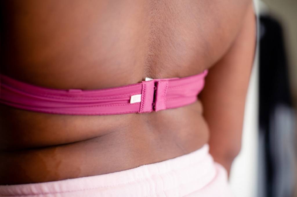Close up of a woman's back wearing a pink bra