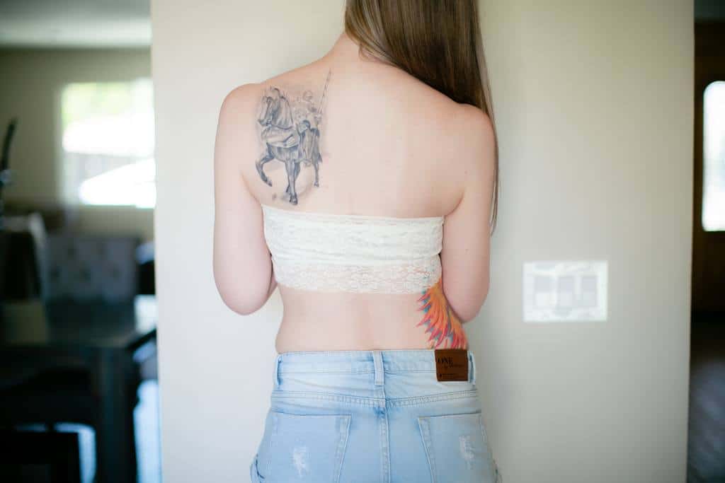 Girl in a white bandeau tube top with tattoo