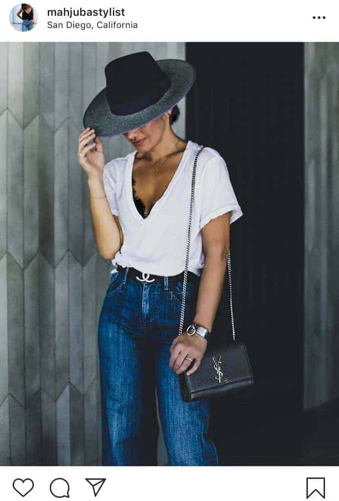 Woman wearing a basic low v-neck white tee with jeans and hat