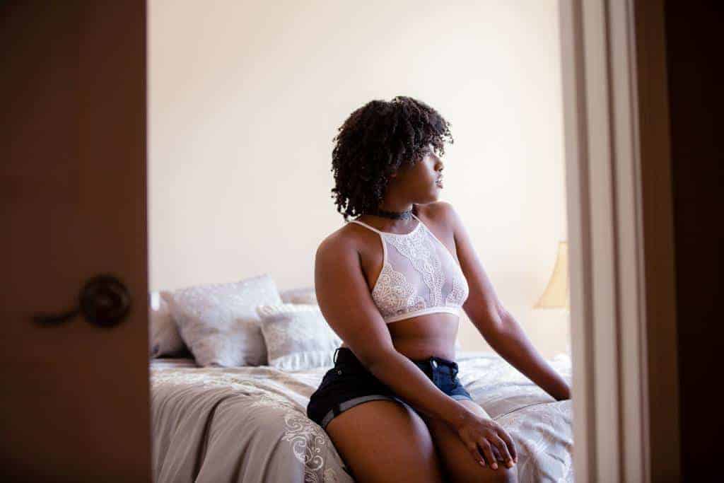 Woman in a white bralette with blue shorts