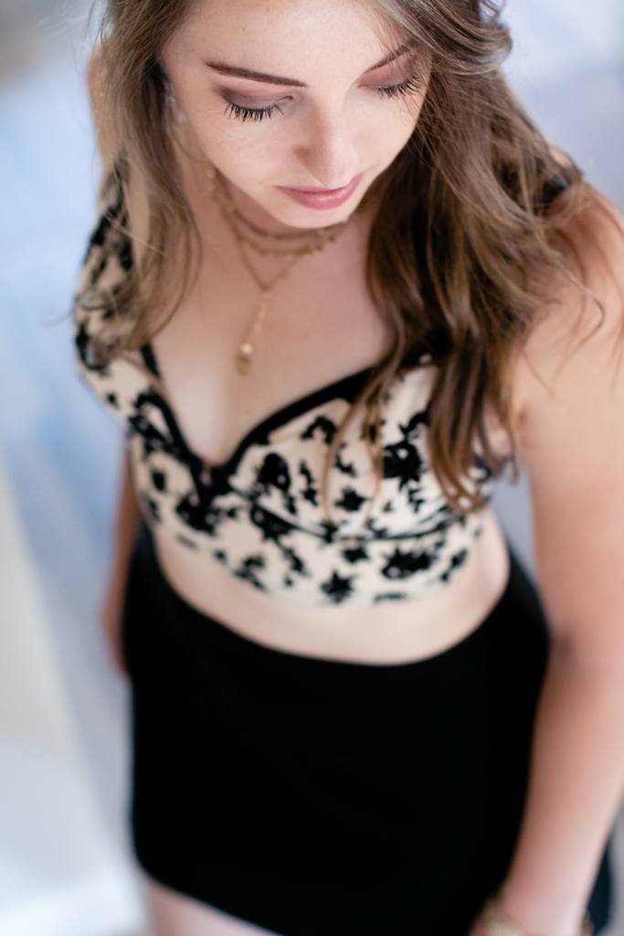 Woman wearing a black and nude printed halter bralette with skirt