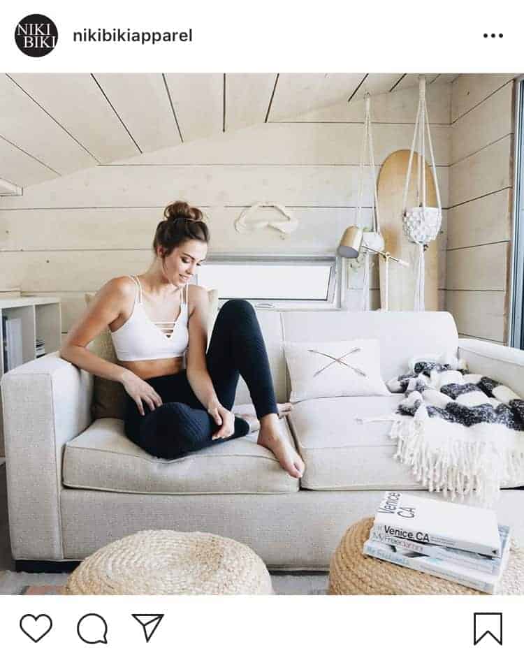 Woman wearing a white strappy bralette with black yoga pants