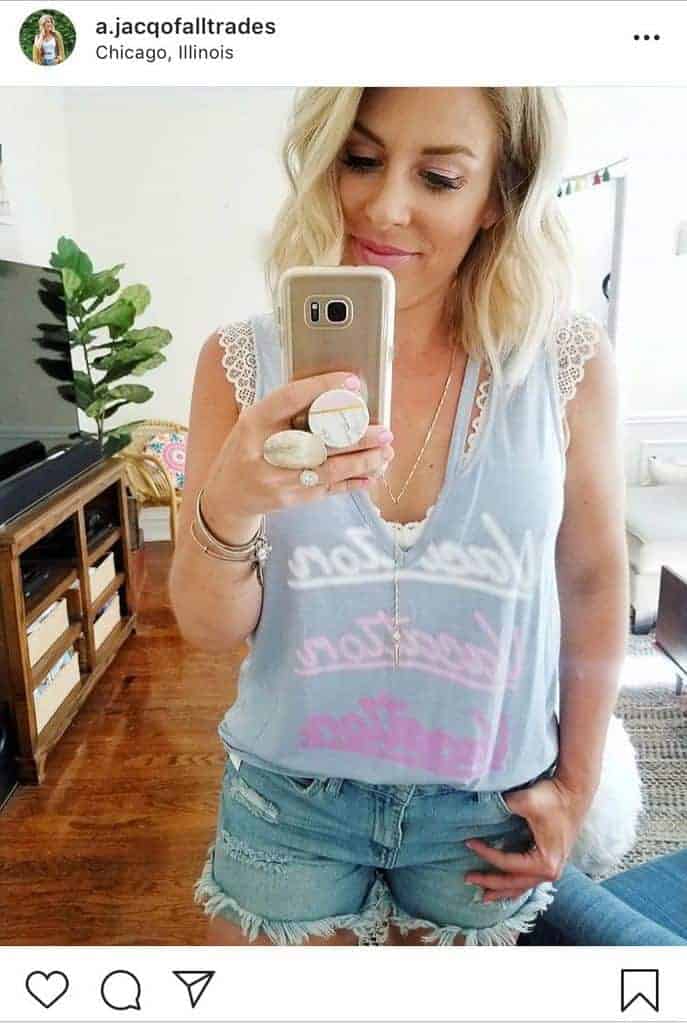 Woman wearing a white scalloped and perforated bralette with powder blue muscle tee