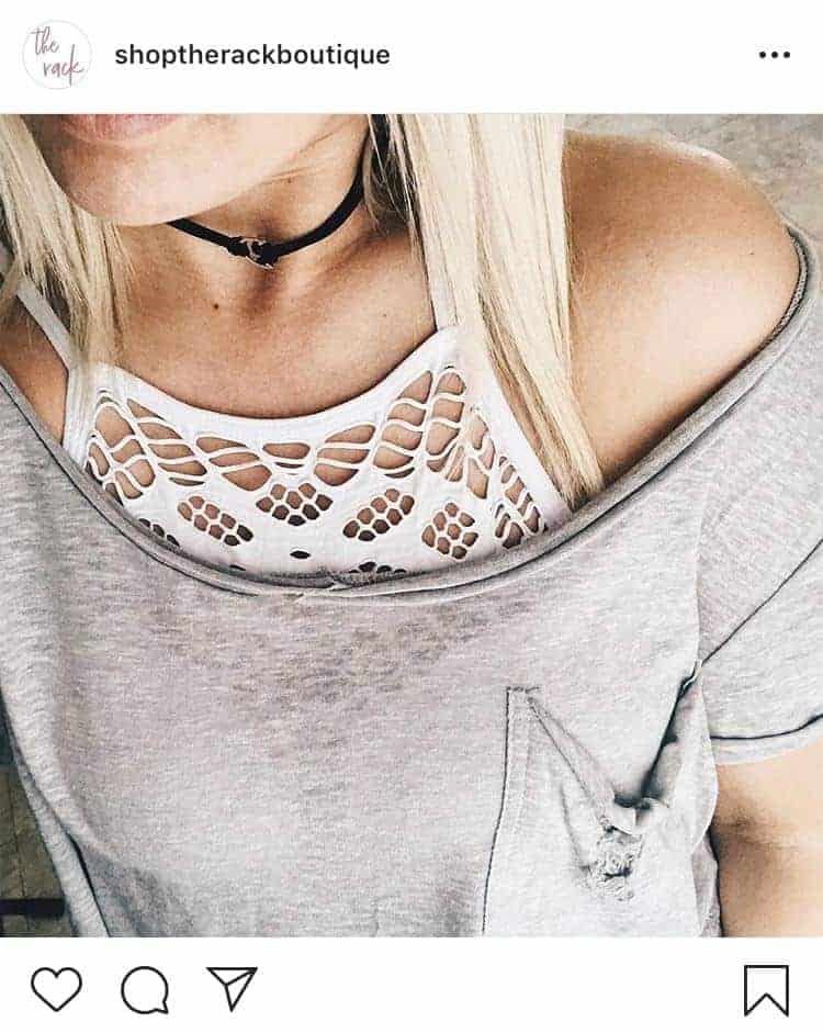 Woman wearing white high neck bralette with gray wide neck t-shirt and black choker