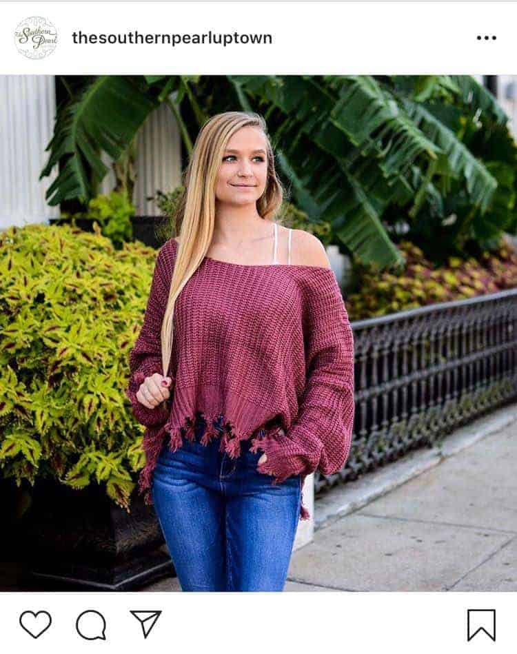 Woman wearing a pink sweater with white strappy bralette
