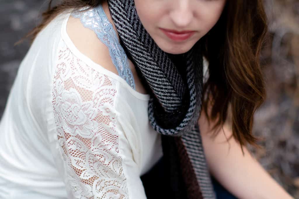 Woman wearing a blue bralete under white top and scarf