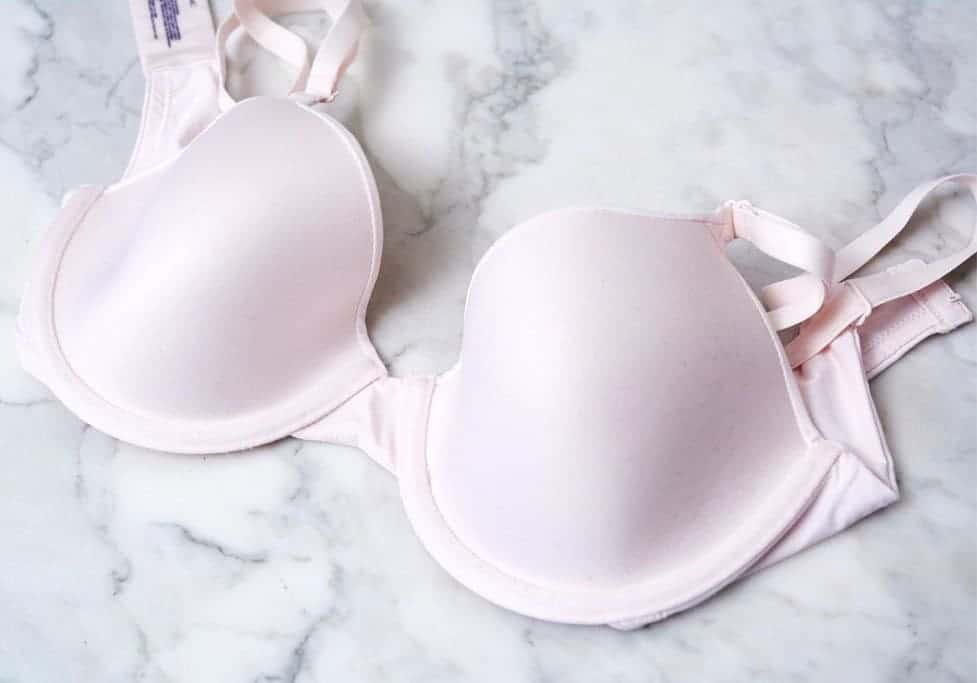 A white push up bra laid on top of a marble counter