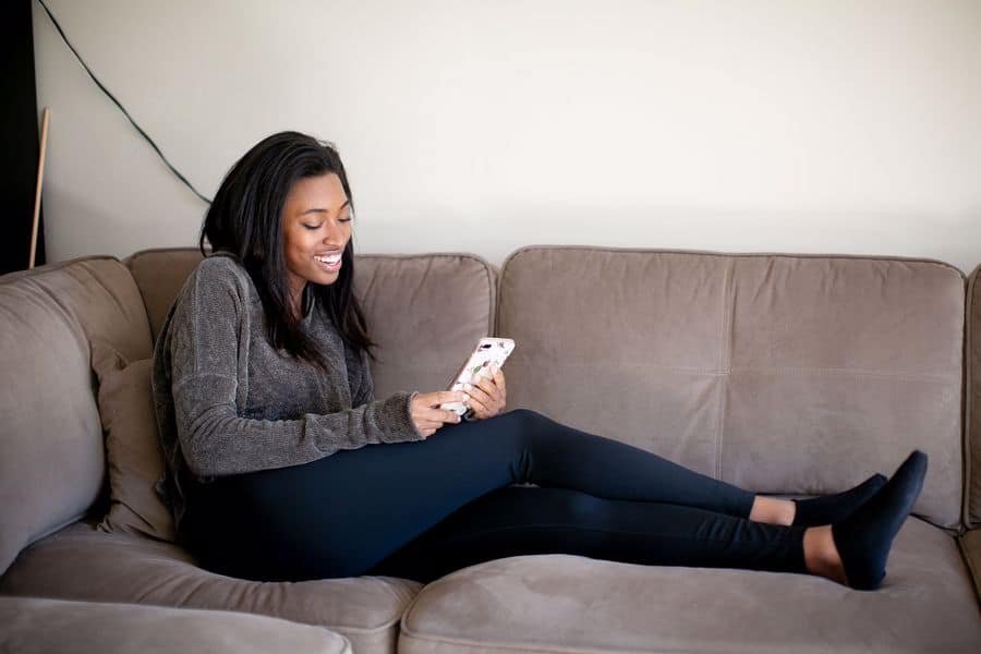 Woman wearing a sweater while relaxing on her sofa
