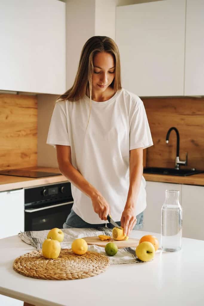 Woman cutting lemons while wearing a white shirt