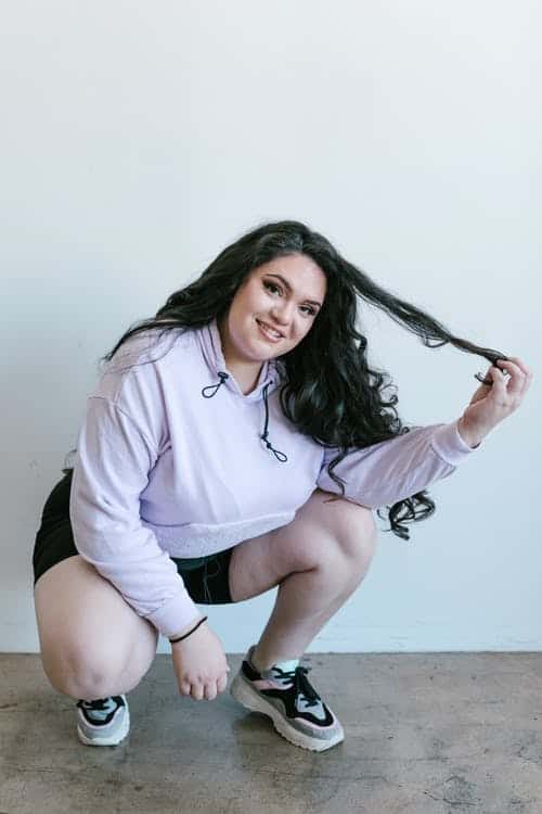 Woman wearing pink hoodie and black shorts