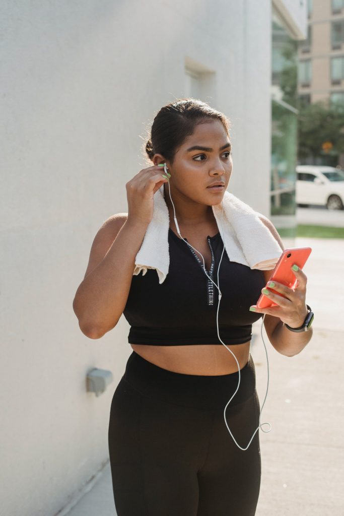 Woman listening to her phone while wearing black sports wear