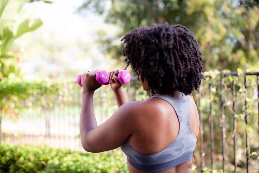 Woman wearing a tie dyed sports bra while lifting weights