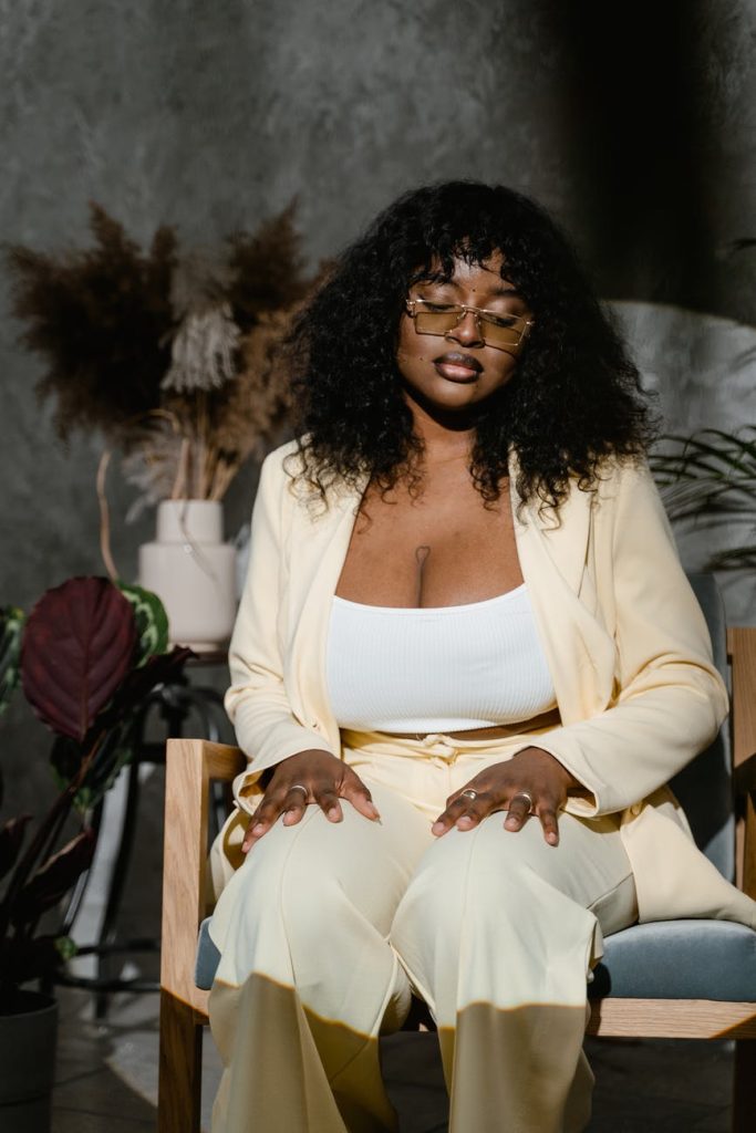 Woman wearing a yellow pant suit set with a cropped top inside