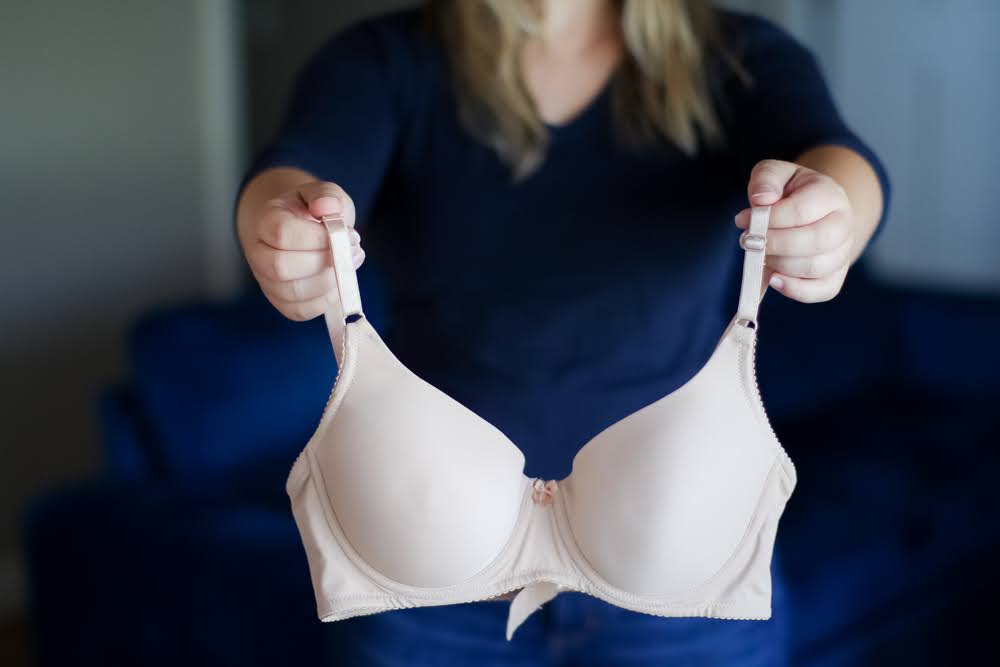 A woman showing a skin tone colored bra