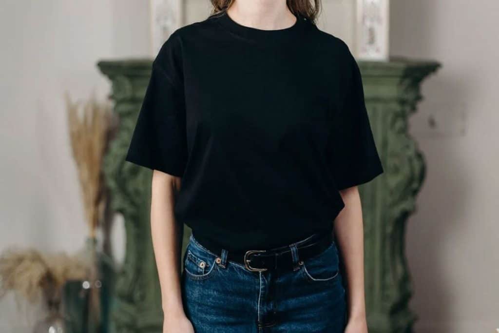 Woman wearing a black shirt and jeans with a black belt