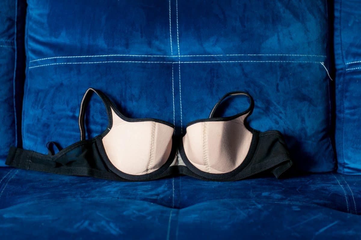 A black balconette bra on a blue background