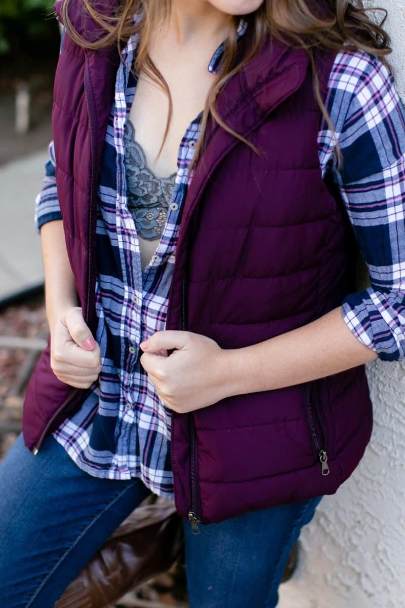 A gray bralette and checkered long sleeves was worn by a woman leaning on a white wall