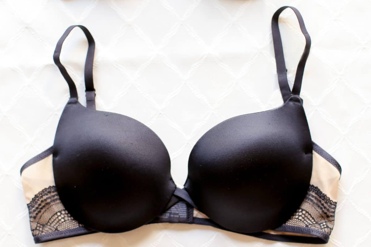 A black push-up bra with lace and black straps placed on a white surface