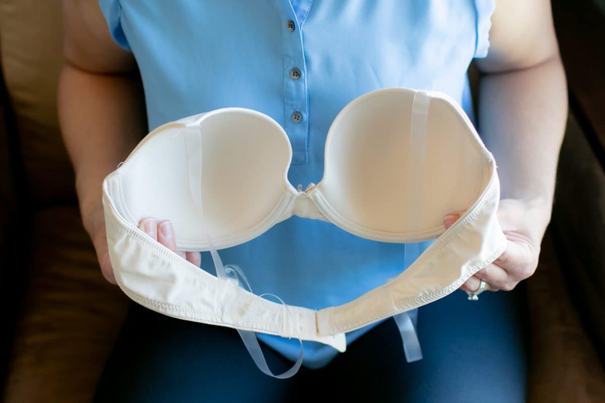 A woman holding a white push up bra