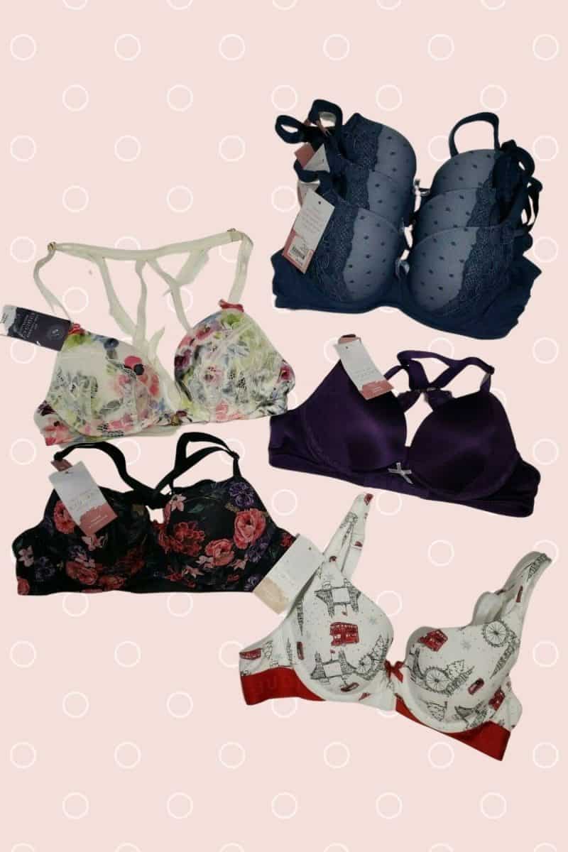 Different colored and styles of bras with foam and underwire on a pink background
