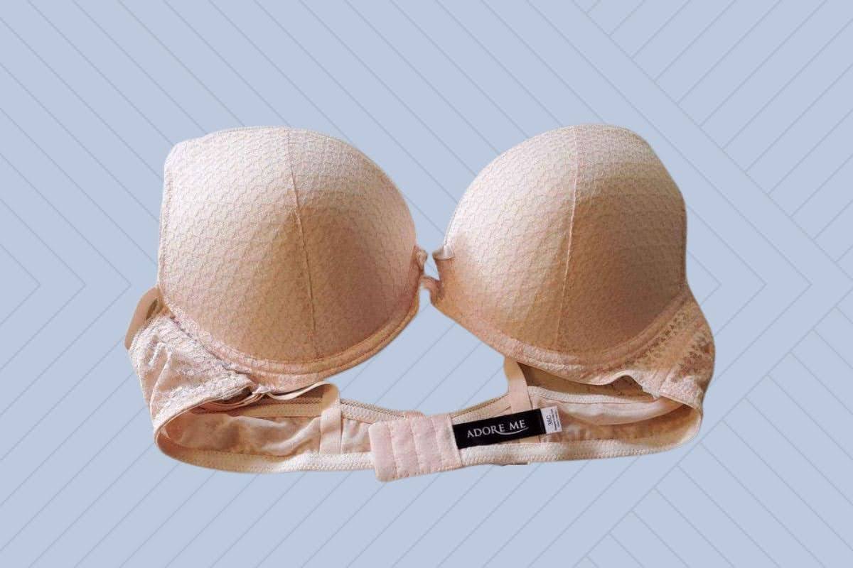 Adore Me strapless underwire bra in cream color placed on a purple background