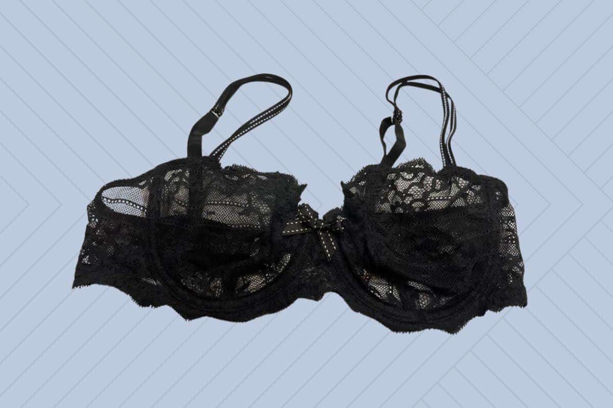 Chantelle black underwire bralette with lace design and a ribbon at the center placed on a purple background