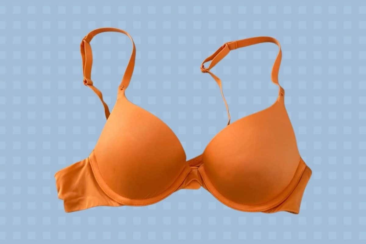 A yellow underwire push-up bra with adjustable straps placed on a blue background