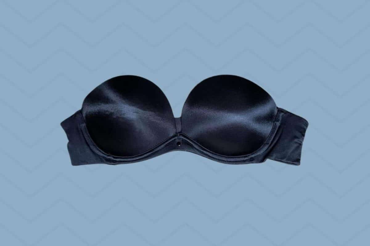 A black strapless bra with a wide band placed on a blue background