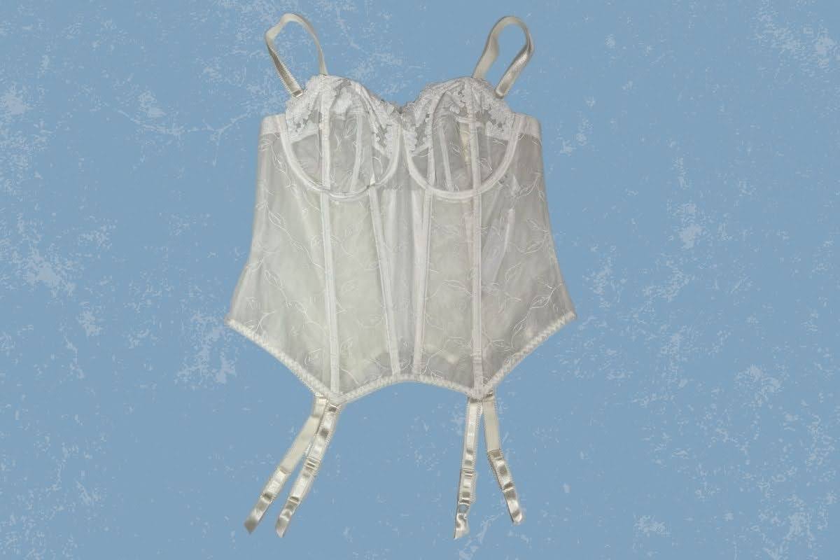 A white basque with an underwire and lace design was placed on a blue background
