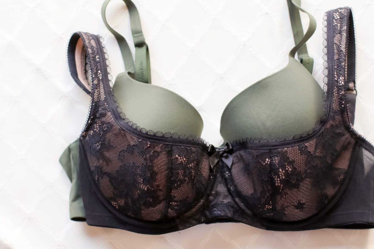 Close-up of two bras a black demi bra and a green full-coverage bra