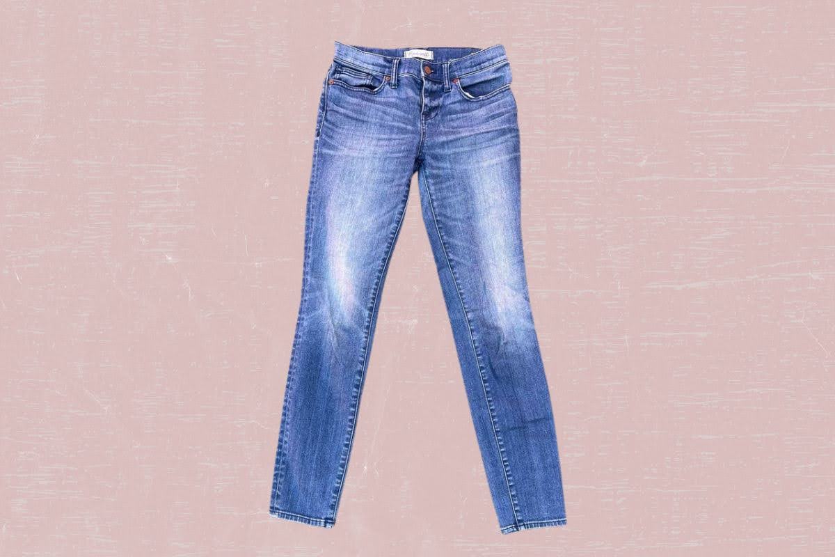 Blue faded denim jeans with pockets placed on a pink background