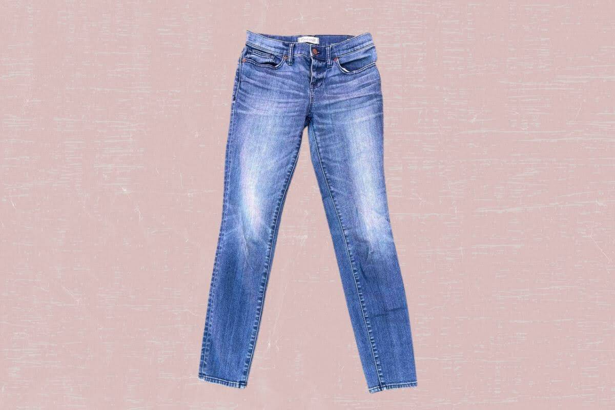 Faded blue denim jeans placed on a pink background