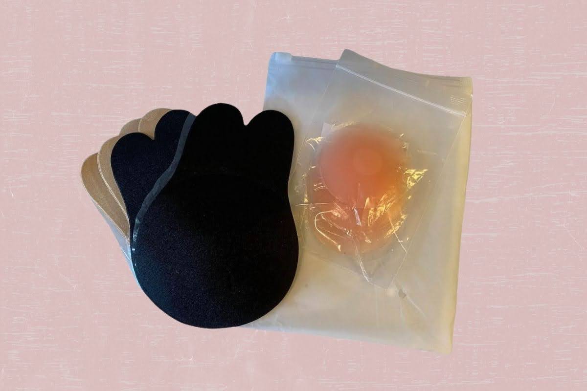 Two pairs of boob tape color black and white and a silicone nipple cover in a plastic container