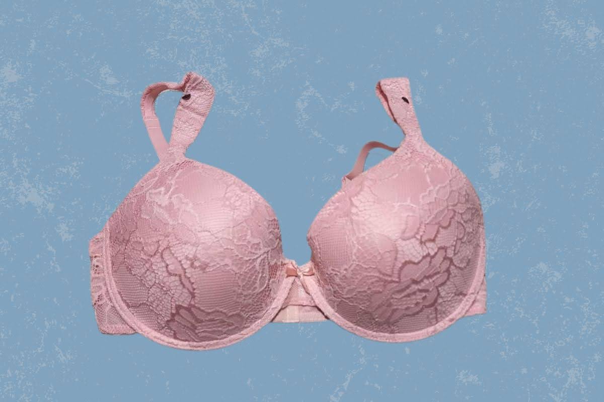 A pink full-coverage underwire bra with lace and adjustable straps placed on a blue background