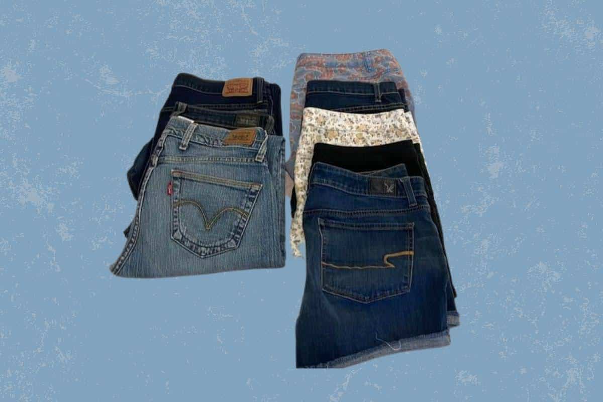 Denim jeans in different colors and styles placed on a blue background
