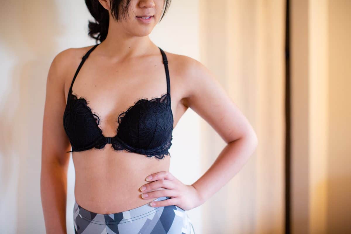 A black racerback lace bralette and colorful leggings are worn by a woman