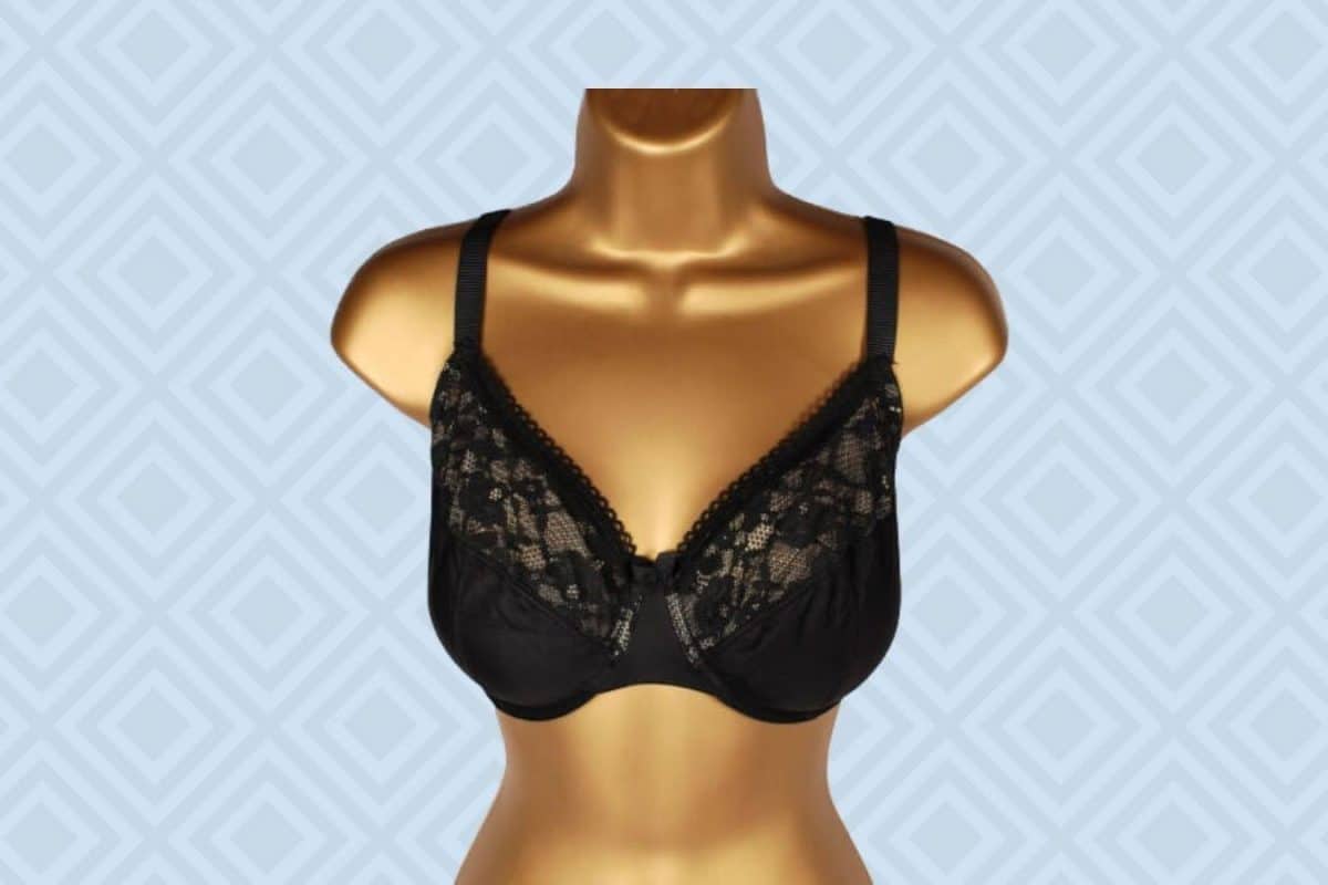A black full-coverage bra with a lace floral design and wide straps placed on a brown mannequin