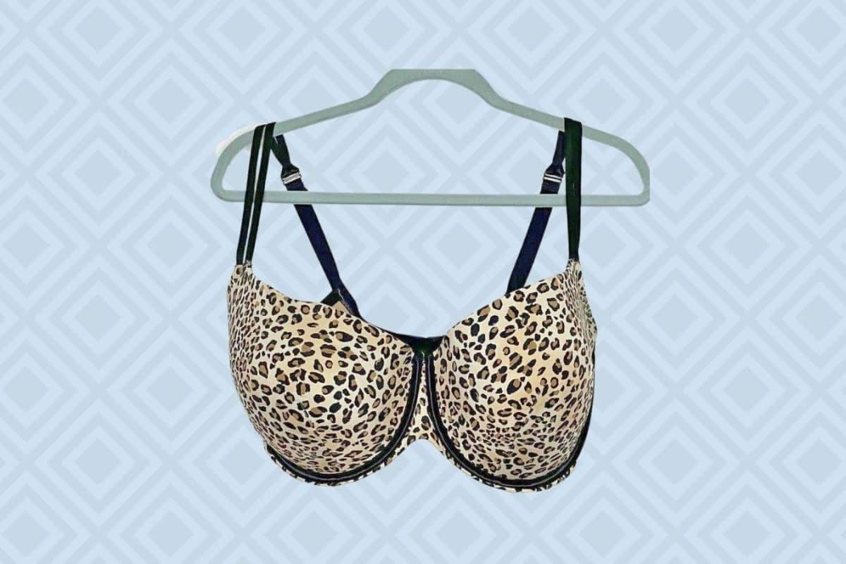 A leopard print push-up bra with underwire hangs on a green hanger