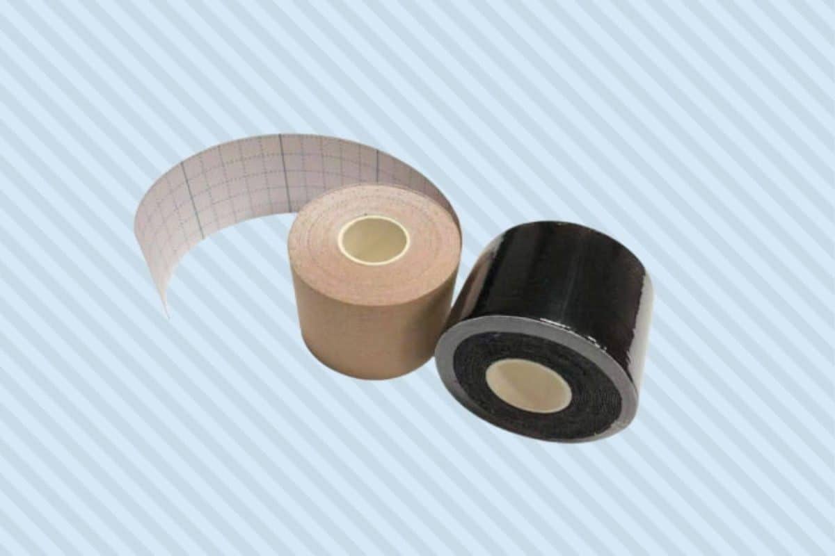 Two rolls of black and cream boob tapes were placed on a striped blue background