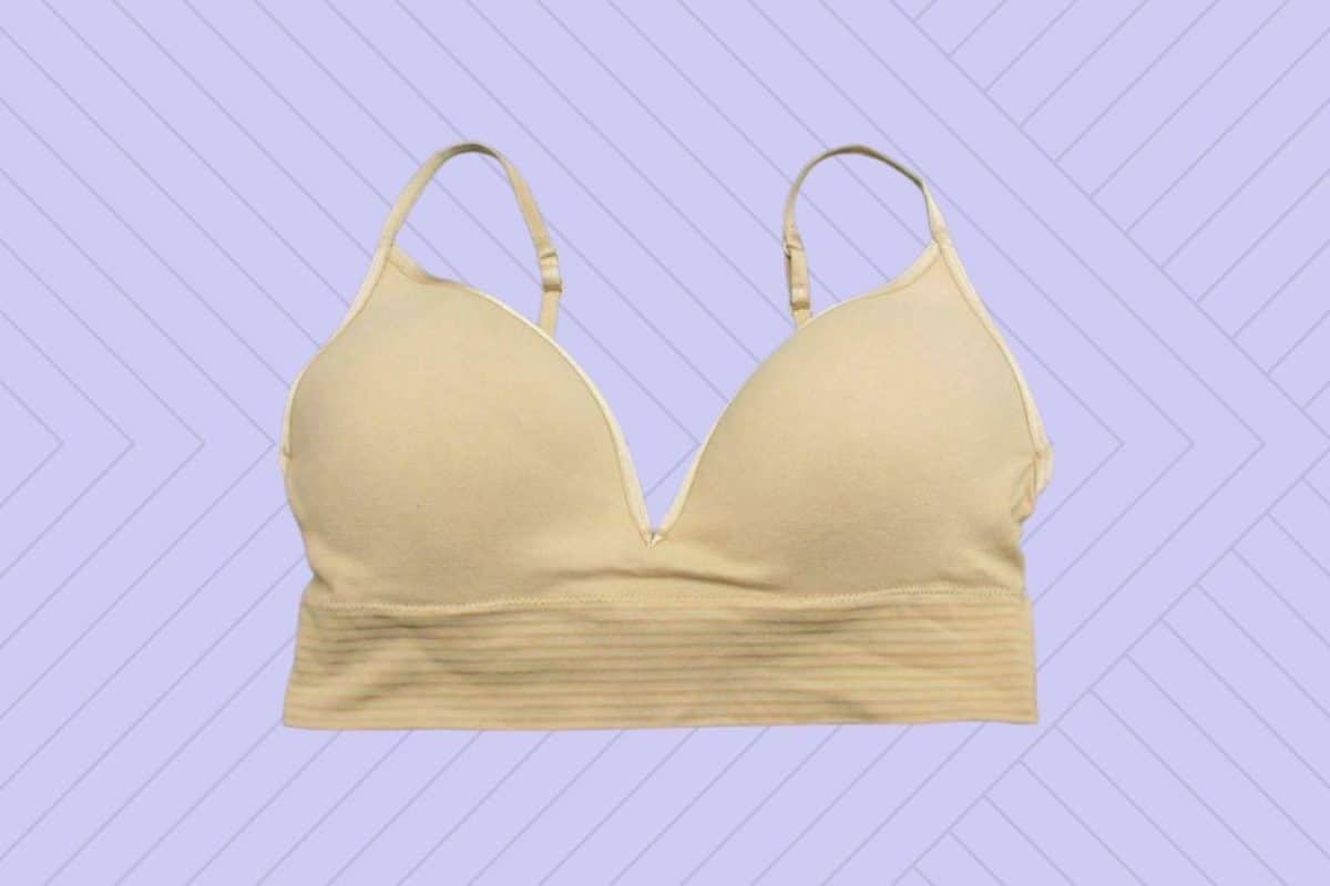 Tan bandage bralette with broad bra bands and adjustable straps on a purple background