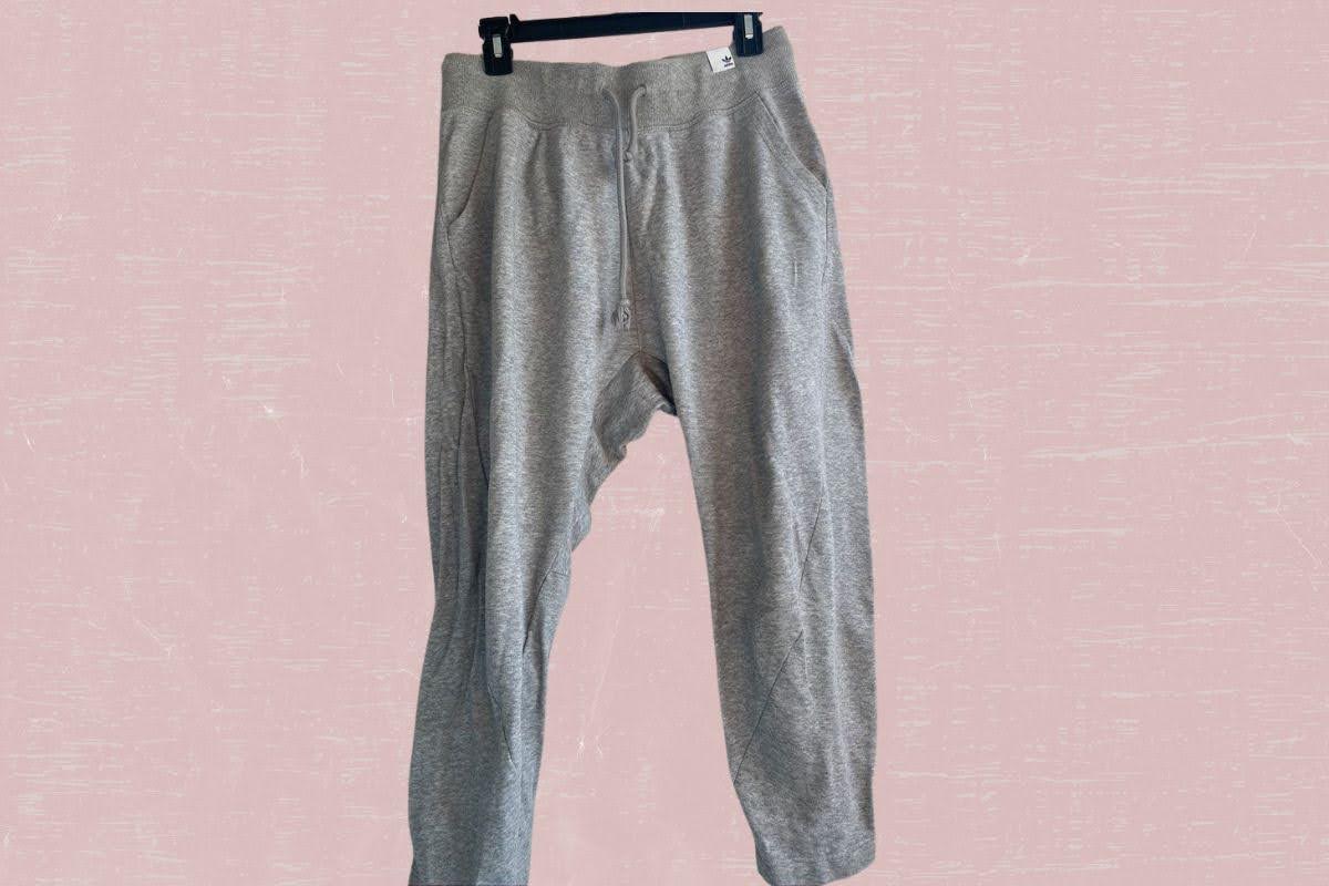 Gray sweatpants with pockets and strings placed on a pink background