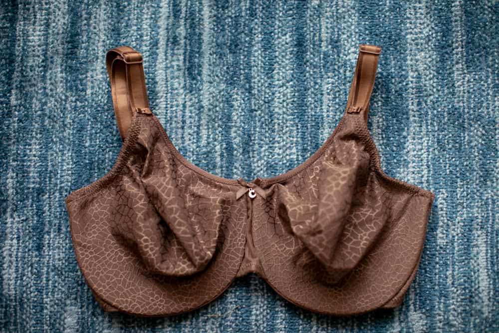 Brown full coverage bra with wide straps and wireless band on a blue blanket