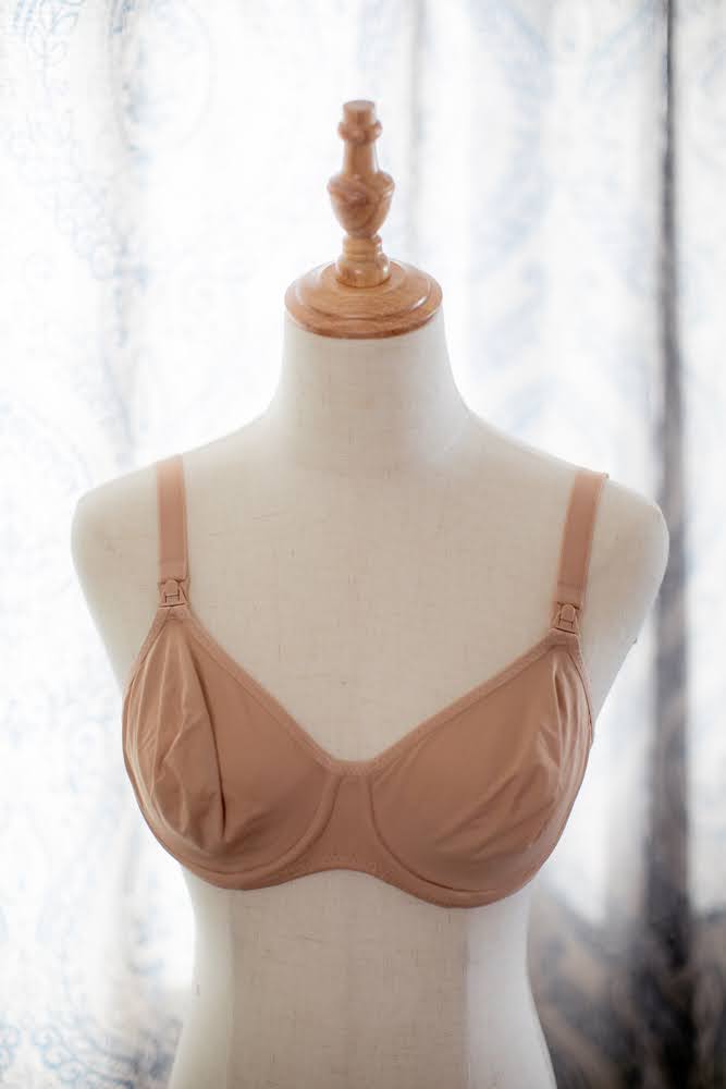 Maternity nursing bra brown in color with front clips and an underwire placed on a white mannequin
