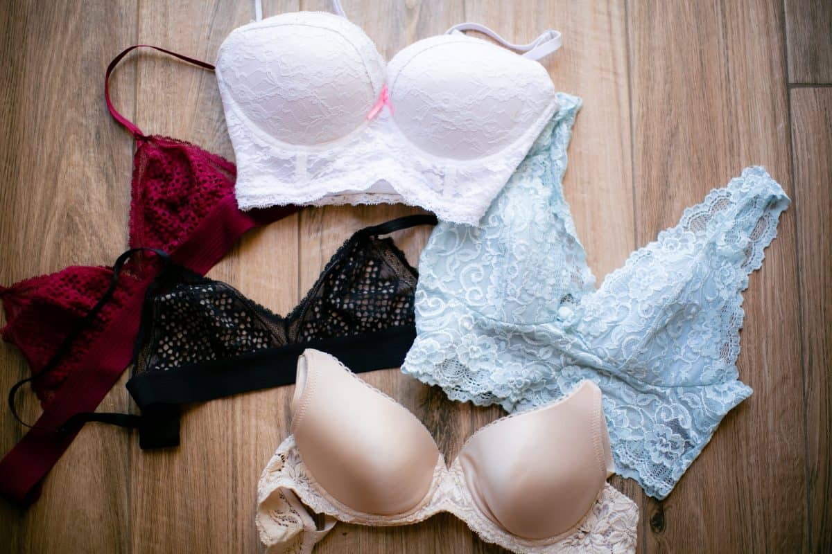 Different colors and styles of bralettes placed on a brown wooden surface