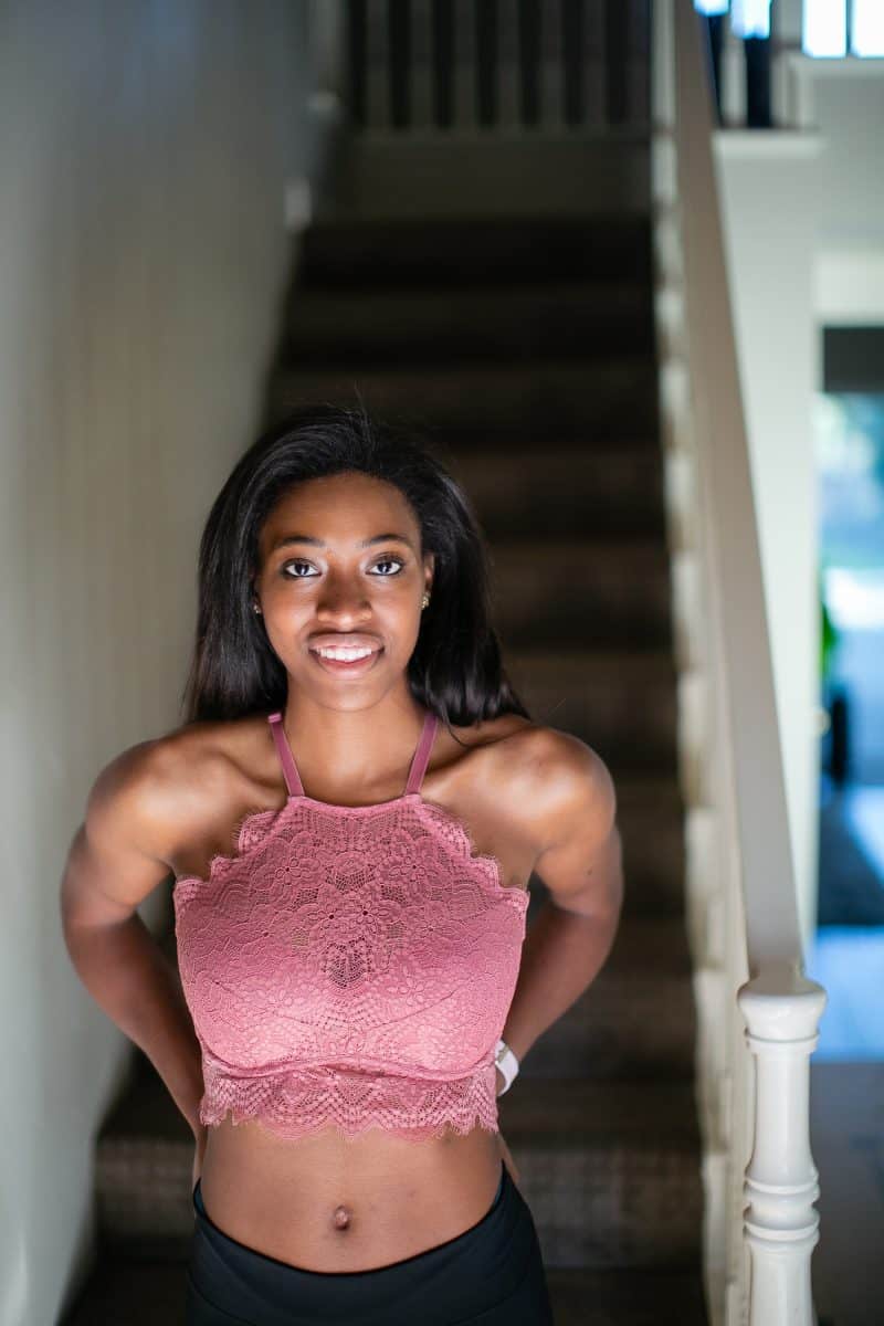 A woman wearing a pink high-neck longline bralette and black leggings