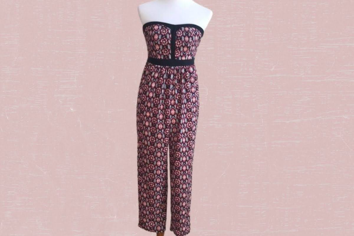 Red floral design tube top jumpsuit placed on a pink background