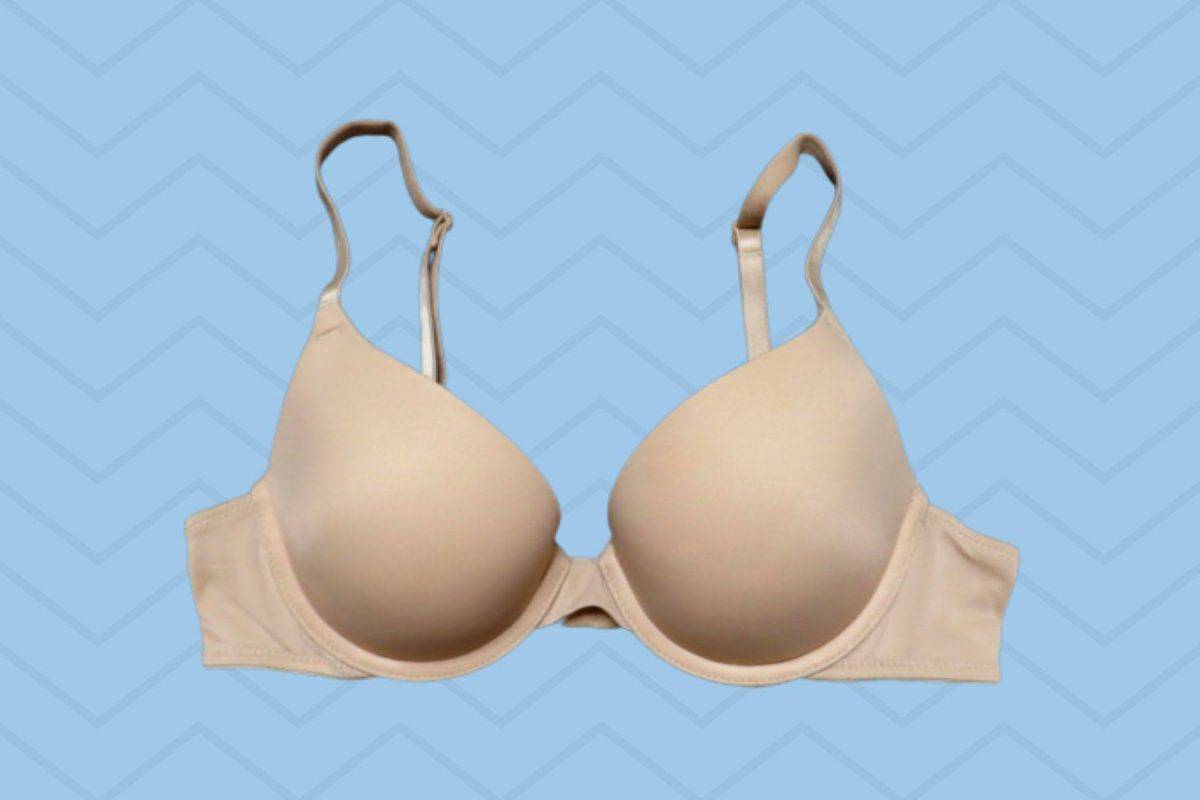 Beige underwired regular bra with adjustable straps placed on a blue background