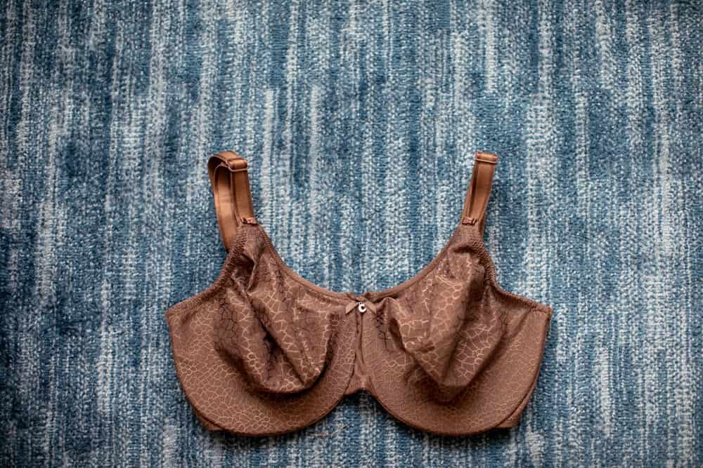 Top view of a brown seamless bra with adjustable straps and ribbon at the center