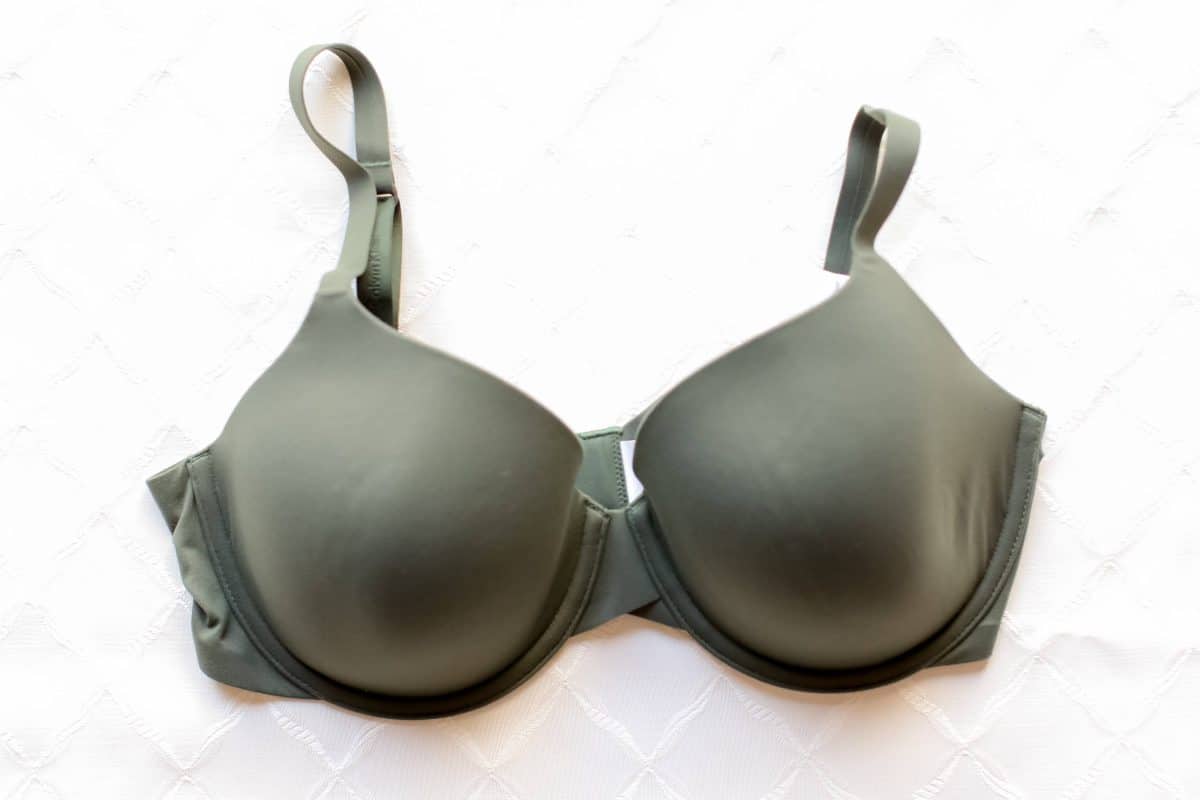 A green push-up bra with underwire and adjustable straps placed on a white surface