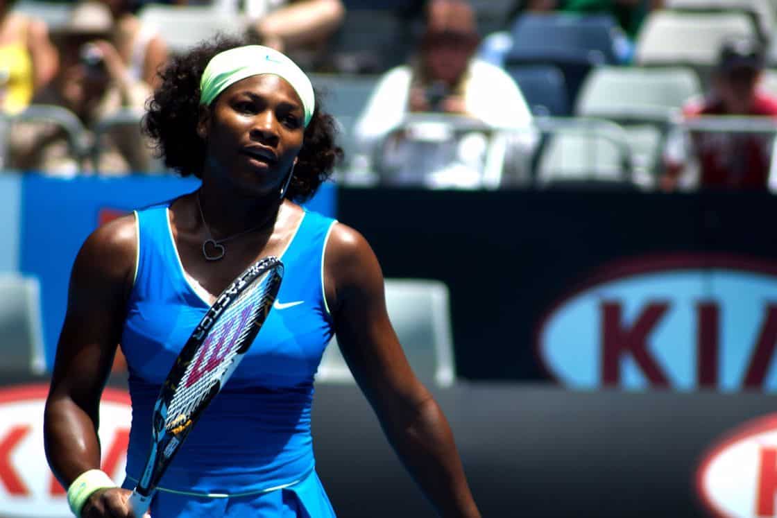Serena Williams wearing a blue tennis outfit and holding a racket